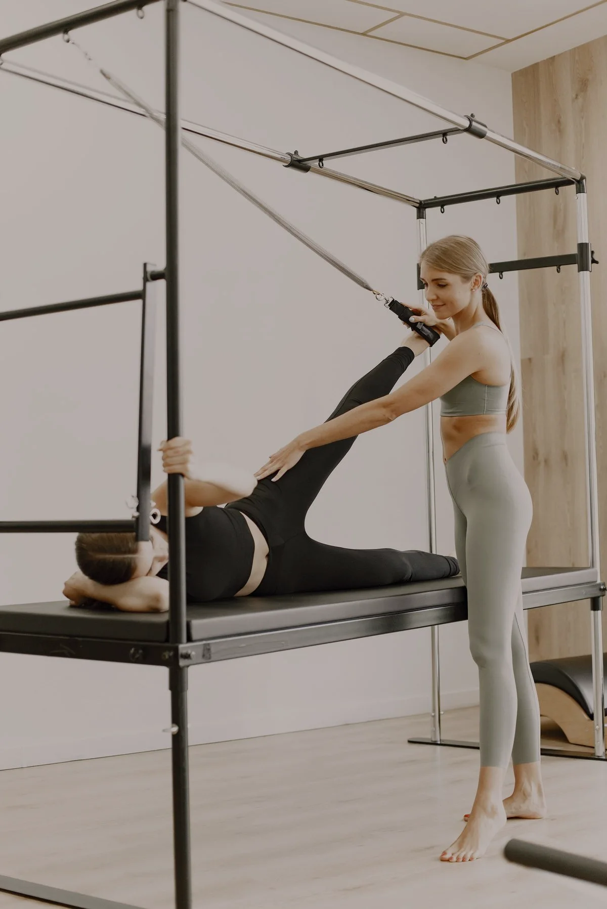 Une coach de Pilates corrige le mouvement d’une élève